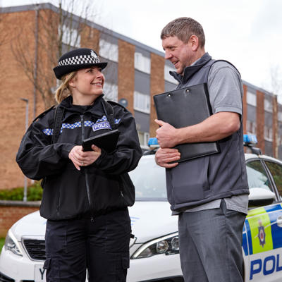 Police Officer speaking to Community Safety Officer in the street.