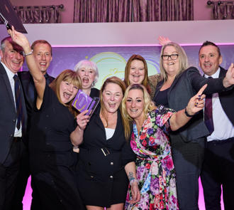 Image of a group cheering at last years LWYL awards with our Chief Executive and Deputy Chief Executive.