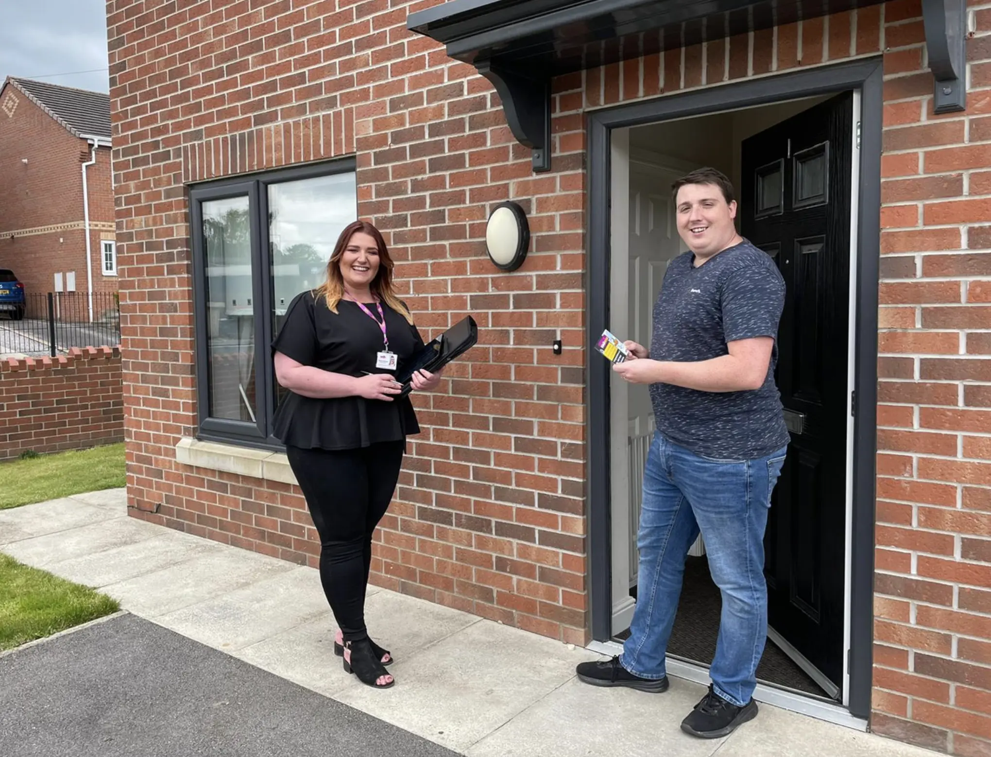 Image of two employees in front of a new build property.