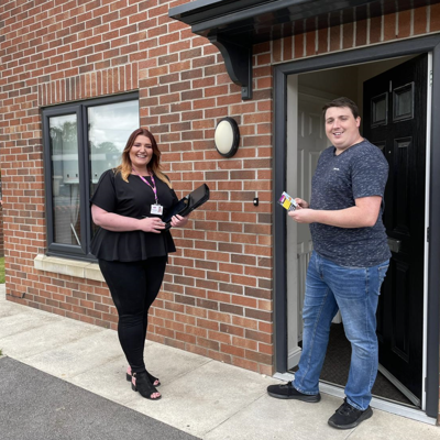 Image of two employees in front of a new build property.