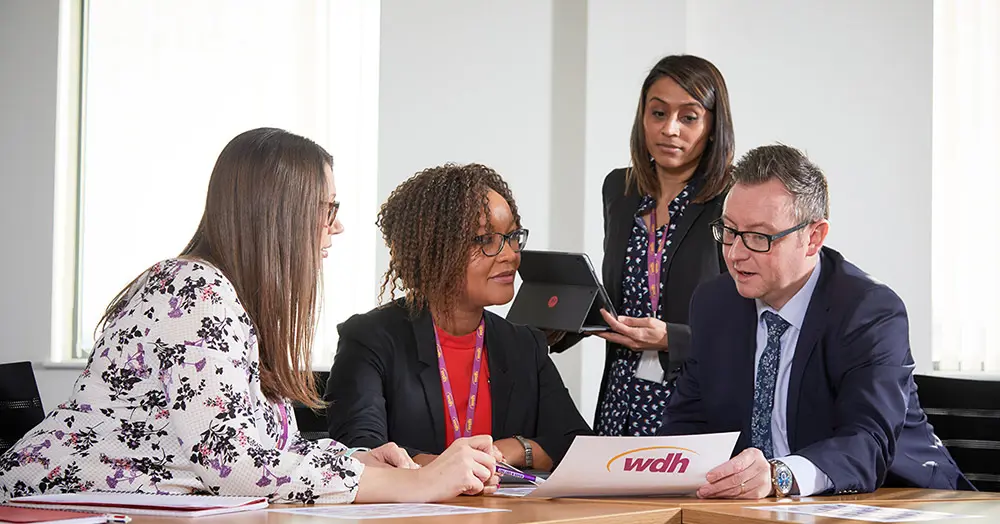 WDH Employees having a discussion around a table.