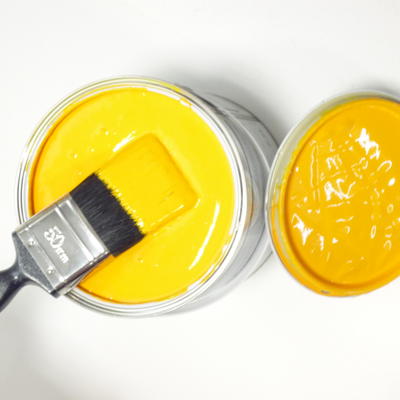 Image of a paintbrush in yellow paint.